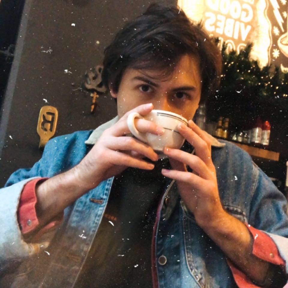 "Noah sips coffee and looks directly into the lens"